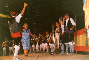 Lucía junto a un grupo de músicos y grupo de baile en unas fiestas de agosto 